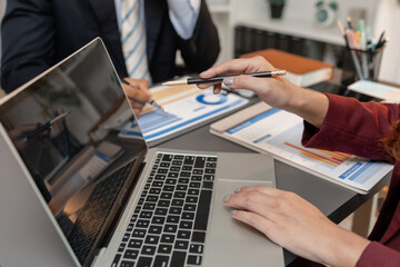 A business meeting scene where professionals review financial charts and exchange insights, highlighting strategic planning and collaborative decision making in a modern office environment.