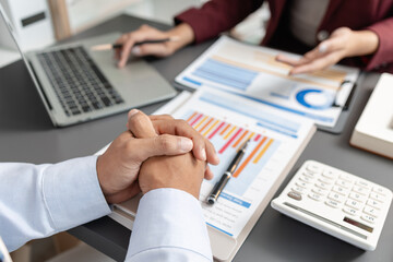Business professionals meeting at a modern office table, reviewing charts and budget reports while discussing key financial insights and strategic plans for upcoming business decisions.