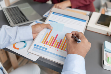 Business colleagues reviewing budget charts together in a modern office, focusing on financial insights, performance metrics, and strategic planning to support upcoming business decisions.