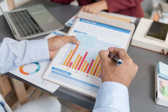 Business colleagues reviewing budget charts together in a modern office, focusing on financial insights, performance metrics, and strategic planning to support upcoming business decisions.
