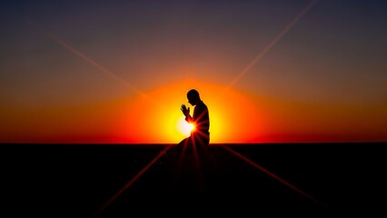 Silhouette of a person standing on a hill against a vibrant sunset with sun rays extending outward.