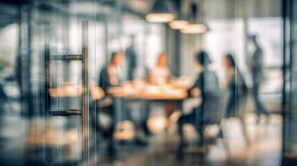 Obraz premium Modern office environment with a glass door in focus and a blurred business team engaged in discussion inside a conference room during a meeting session