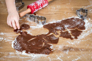 Child Making Holiday Cookies With Gingerbread Dough And Festive Cutout Shapes