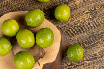 green ripe citrus limes on a wooden table in the kitchen, ripe and juicy lime fruits for cooking both sauces and drinks and other food