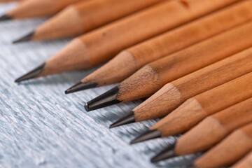 pencils with black lead on blue paper, several monochrome pencils for sketches or graphic work are in a row.