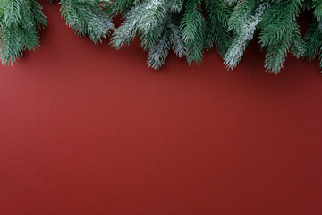 Christmas frame top border of snowy pine branches on red background. Greeting card design.