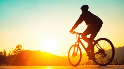 Naklejka premium Cyclist enjoying a sunset ride on a peaceful mountain trail