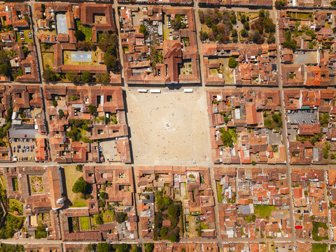 Aerial view of the expansive Plaza Mayor, a sun-drenched gathering place framed by terracotta-roofed colonial architecture, Villa de Leyva, Boyaca, Colombia.