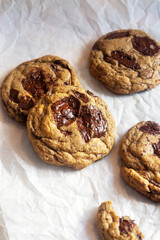 freshly baked homemade chocolate chip cookies on baking paper background