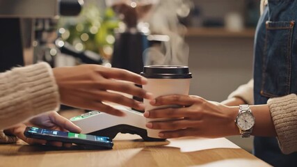 Customer paying for hot coffee with smartphone using contactless mobile payment near point of sale terminal - Powered by Adobe