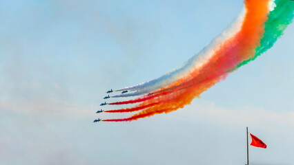 Aerobatic team Frecce Tricolori of the Italian Air Force, National Aerobatic Team. Airshow performance with aircraft, flight of pilotage team with colorful smoke trails. Planes and jets in the air.