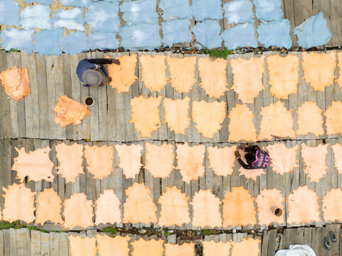 Aerial view of tanned hides drying on wooden planks under the sun, the scene a patchwork of textures and tones, Dhaka, Dhaka Division, Bangladesh.