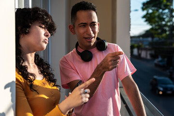 Young friends observing city view while sharing a quiet tech moment