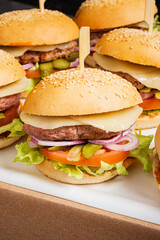 Savory burgers piled high with fresh lettuce, tomatoes, onions, and pickles invite hungry diners