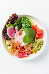 A vibrant salad bowl features fresh greens, radishes, and delicious toppings
