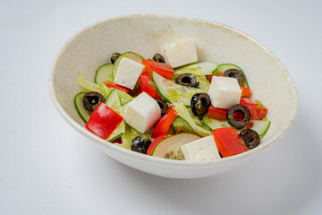 Colorful salad featuring crisp cucumbers, red peppers, black olives, and feta cheese in a bowl