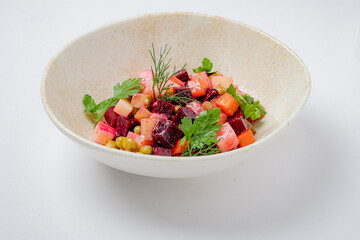 Vibrant mix of beets, cucumbers, and carrots topped with fresh herbs in a unique bowl