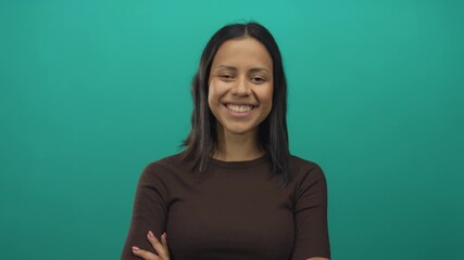Hispanic woman in brown top smiling confidently against an isolated green background wall, capturing a modern and approachable vibe. - Powered by Adobe