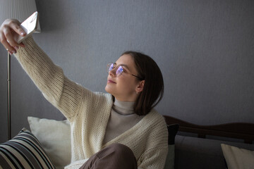 Smiling young woman taking a selfie with smartphone