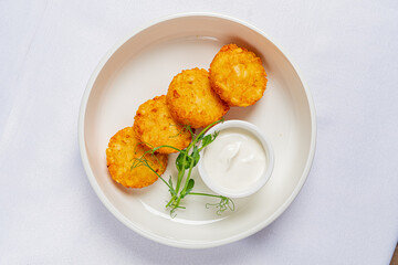 Delicious golden potato croquettes served with a smooth, creamy dip and fresh greens