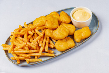 A tempting platter features golden chicken nuggets, crispy fries, and dipping sauce