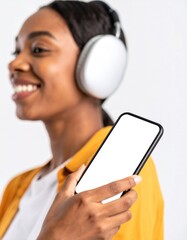 Happy African American Woman Listening to Music with Wireless Headphones, Holding Smartphone with Blank Screen
