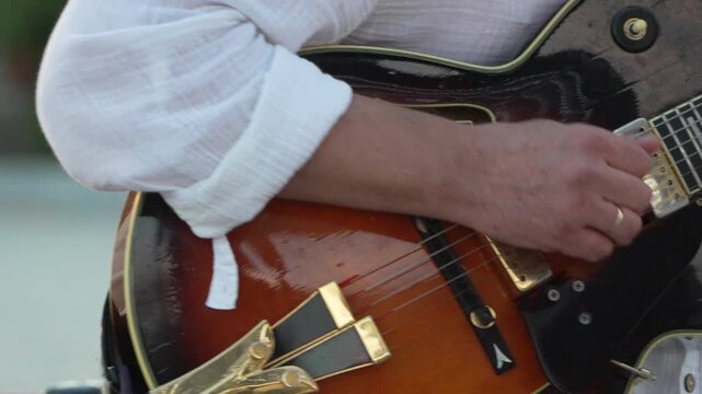 Guitarist, Electric Guitar, Music: Male musician playing a hollow body jazz guitar with a pick - Powered by Adobe