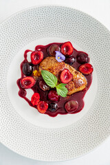 Succulent duck breast beautifully plated with a rich cherry sauce, topped with vibrant fresh fruits