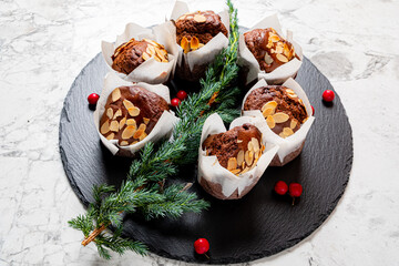 Delicious almond muffins arranged beautifully on a dark slate platter with seasonal decorations