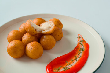 close up of several round-shaped French fries filled with mayonnaise sauce blended with melted cheese