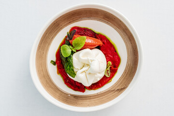Indulging in a colorful dish featuring fresh burrata, vibrant tomato sauce, and herbs