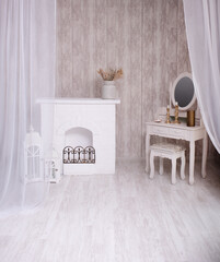 in a bright room with a fireplace stands a table with candles and mirror