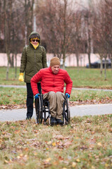 a woman watches as a man in a wheelchair prepares to drive across the grass in his chair