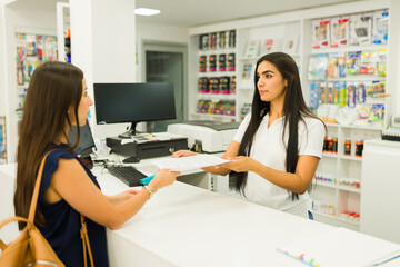 Employee delivering documents to female customer at print shop