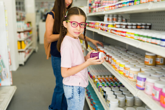 Little girl shopping for colorful art supplies back to school - Powered by Adobe