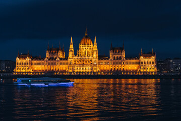 Fototapeta premium Budapest parliament at night with boat