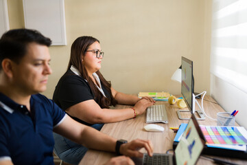Couple working from home remotely on computers, focusing on online business and digital tasks in their office