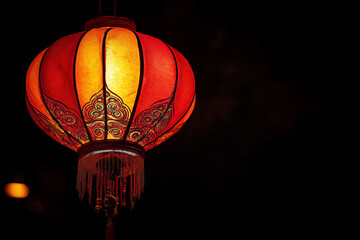 Obraz premium Elegant Mid-Autumn Festival lantern radiates warm hues of orange and gold isolated on a black background
