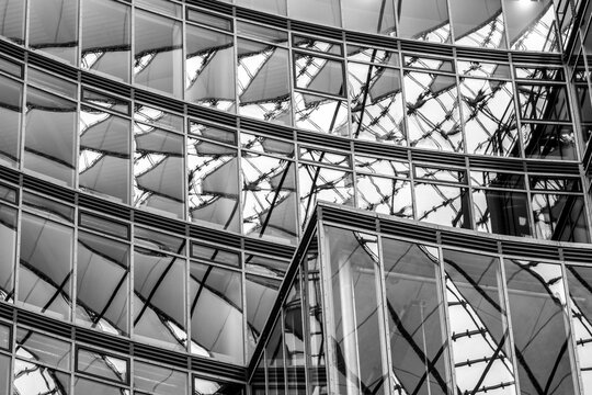 Abstract reflection merging architecture through glass facade patterns where symmetry enhances modern office surfaces and geometric lines define contemporary urban design