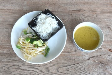 rice noodles on plate with spicy crab curry sauce in bowl eat couple fresh vegetable