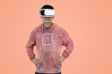 Excited young Asian man wear hoodie reacting with joy while wearing a virtual reality headset, symbolizing the thrilling first experience in studio background