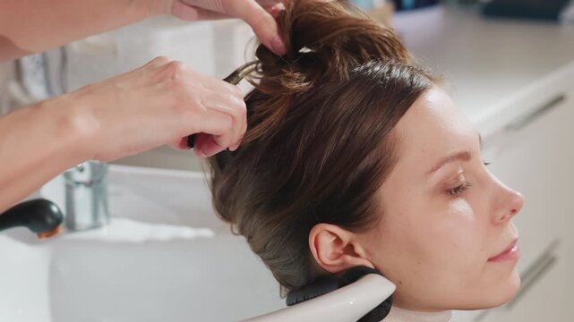 relaxed salon ambiance with secure hairstyle, practiced stylist gently creating elegant updo, graceful hair arrangement process occurring within tranquil salon setting by skilled stylist