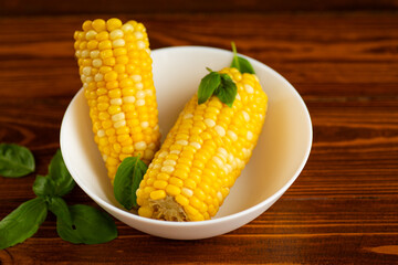 two ears of boiled corn in a white plate