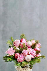 Modern Christmas pink decoration with roses, fir and baubles. Postcard motif.