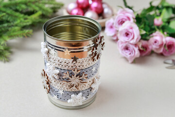 Florist at work: woman shows how to make modern Christmas decoration with fir, roses, pink baubles and decorative stars. The base is classic can. Step by step, complete tutorial.