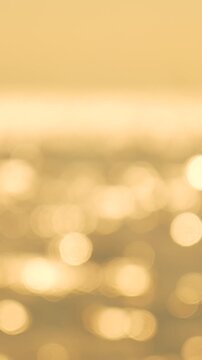 Sun Water Bokeh. Sparkling sun reflections on tranquil water create a beautiful abstract golden hour bokeh effect. Vertical video.