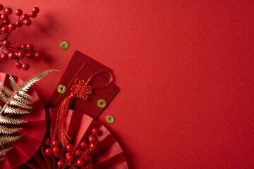 Bright red scene celebrates Chinese New Year with red envelopes, decorative knots, gold coins,...