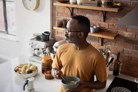Man Eating Breakfast While Looking Thoughtfully Away
