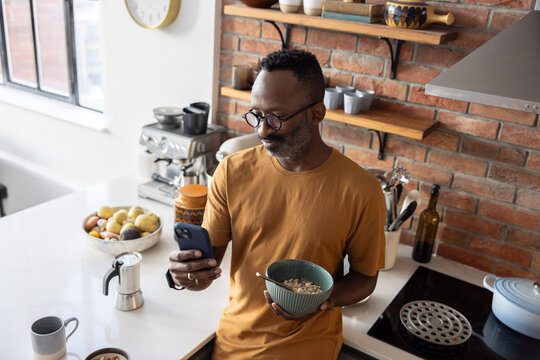 Man enjoying breakfast and checking his smartphone