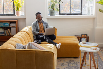 Mature man comfortably using a laptop at home for personal finance